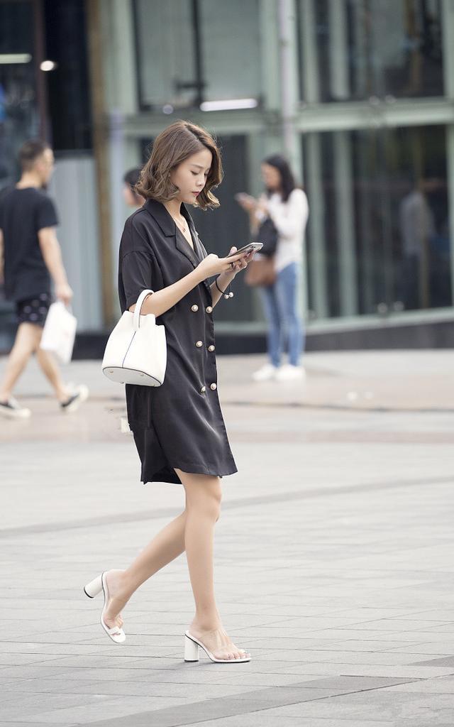 路人街拍，小姐姐身穿黑色紧身的低领露脐的短袖，很有视觉冲击力