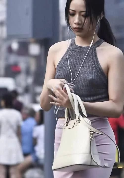 街头穿着时尚的美女,高腰包臀裙把身材比例拉伸的不错