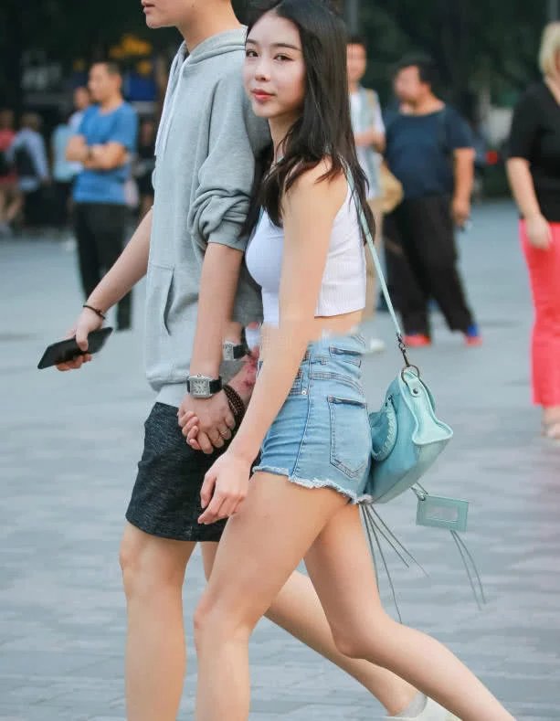 甜美小姐姐露脐装秀出白皙小蛮腰，超短裤裹出浑圆曲线，丸子头俏