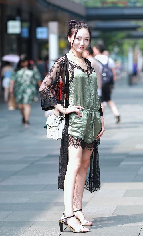 路人街拍，小姐姐身穿黑色紧身的低领露脐的短袖，很有视觉冲击力