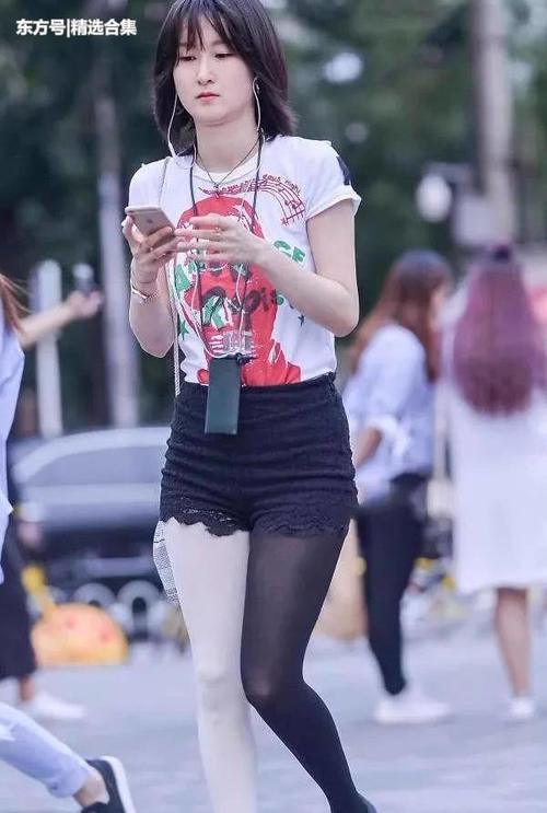 街拍：气质小姐姐高挑热裤显苗条修长双腿，黑白丝袜非常有个性