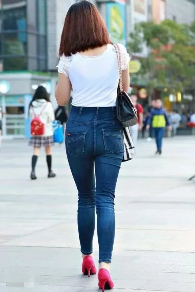 气质小姐姐白色T恤搭配牛仔裤,紧绷感十足,边走边玩手机很洋气
