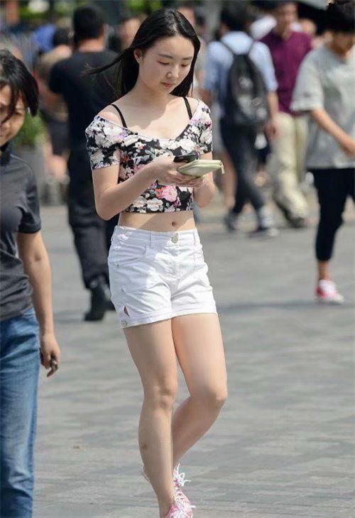 「身穿」街拍:身穿白色镂空小衫+蓝色紧身短裤的小美女,美感十足