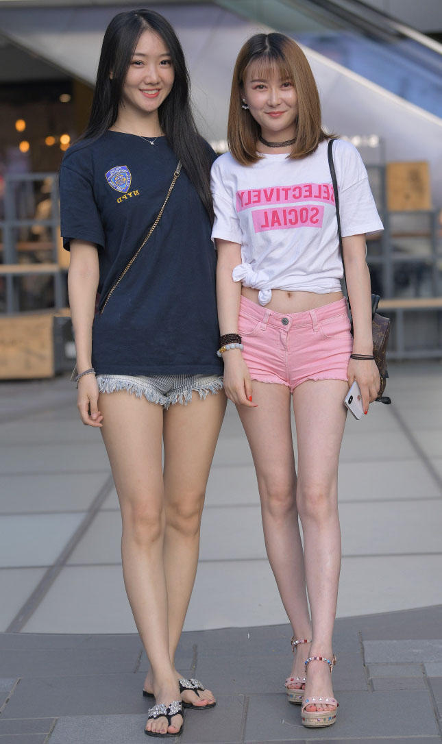 时尚姐妹花穿超短裤相约出街秀出两双修长的美腿，裤子一个比一个