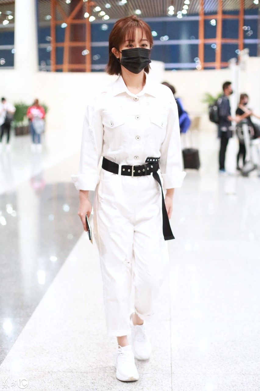 杨紫现身北京机场一身白色制服搭配黑色腰带帅气潇洒，网友这发型