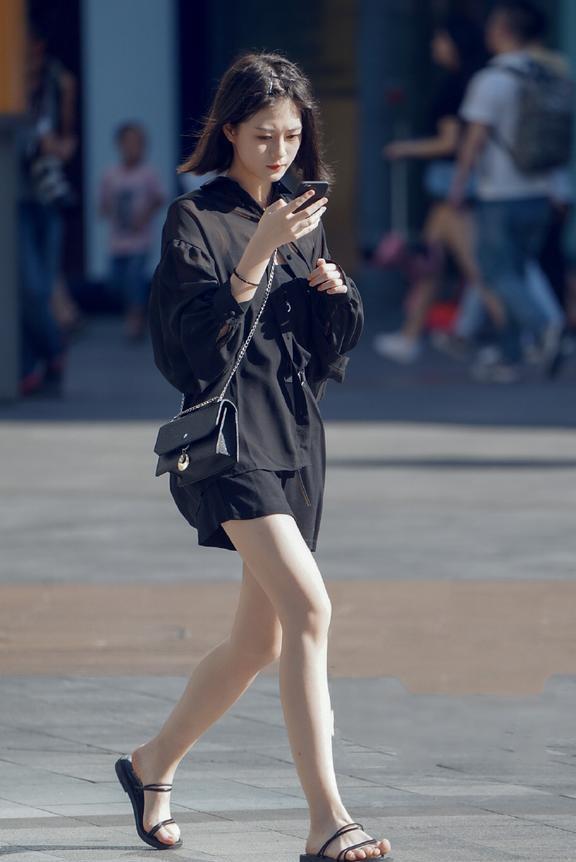 穿着紧身长裙，腿部开衩的设计让美女看起来格外的性感！