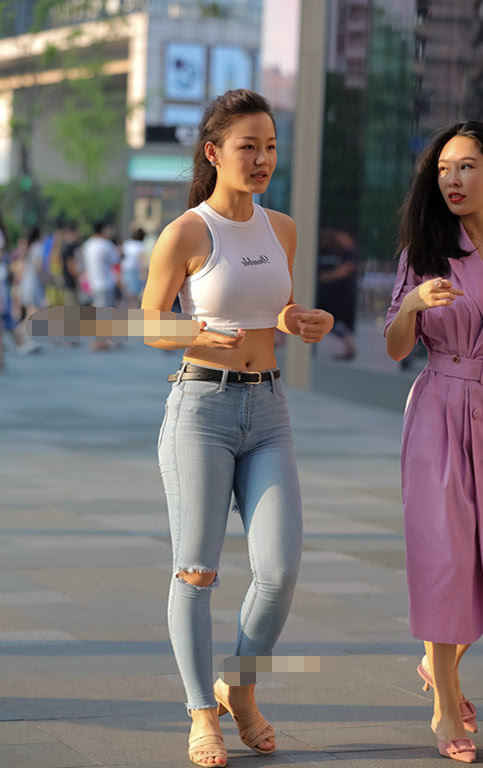 气质小姐姐清爽的紧身牛仔裤展现玲珑有致的线条，街头靓丽的风景