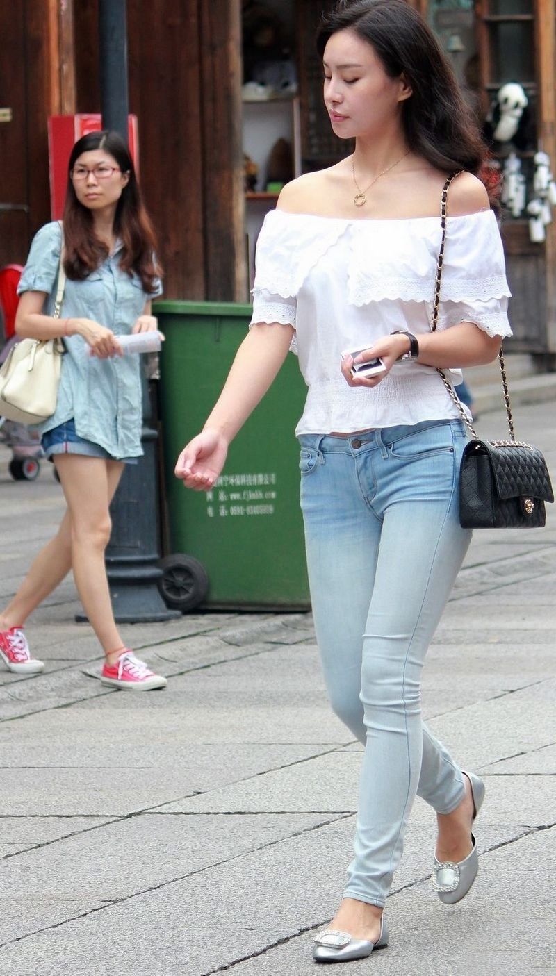 街拍:紧身牛仔裤露肩装美女，纤细的身材引人瞩目