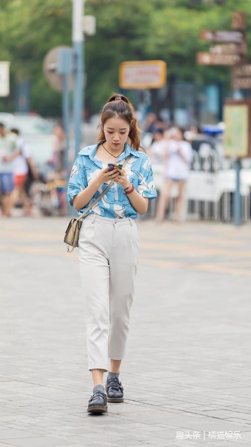 路人街拍，小姐姐穿吊带衫配紧身牛仔裤，身姿靓丽，气质出众！