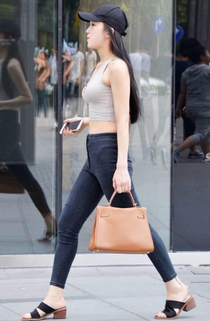 气质小姐姐紧身背心勒出了丰满的上围，一双修长的美腿很是吸睛