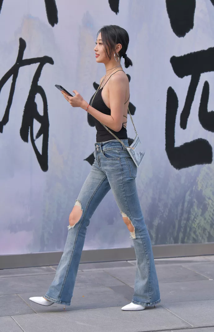 路人街拍，黑色上衣搭配牛仔裤，展示性感好身材，时尚潮流有魅力