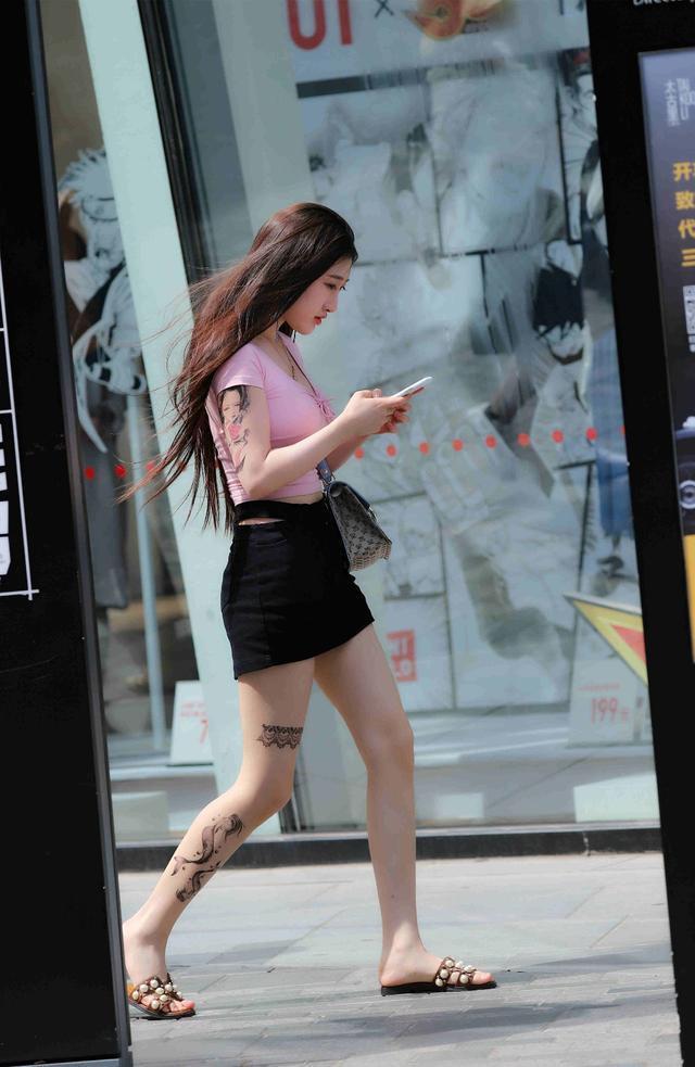 路人街拍，小姐姐T恤搭配黑色的短裙，很是性感