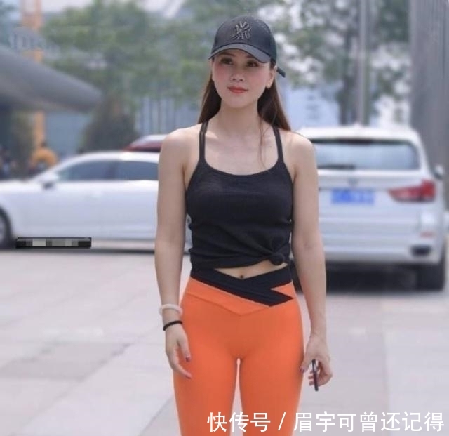  显得■路人街拍，小姐姐橘色打底裤搭配吊带背心，显得非常绚丽