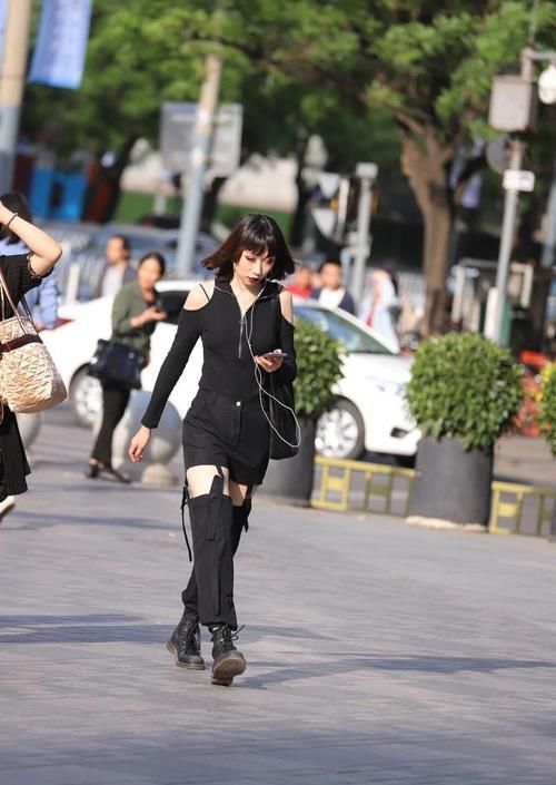  看起来：路人街拍，小姐姐穿着一件橄榄绿色的上衣，看起来非常的清纯