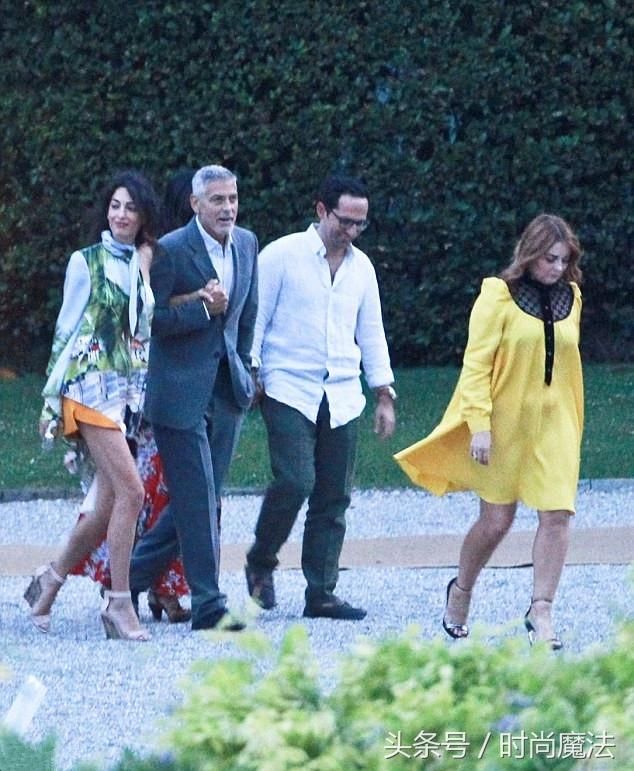 阿马尔克鲁尼穿着橙色短裤，与丈夫乔治一起在科莫湖共进晚餐