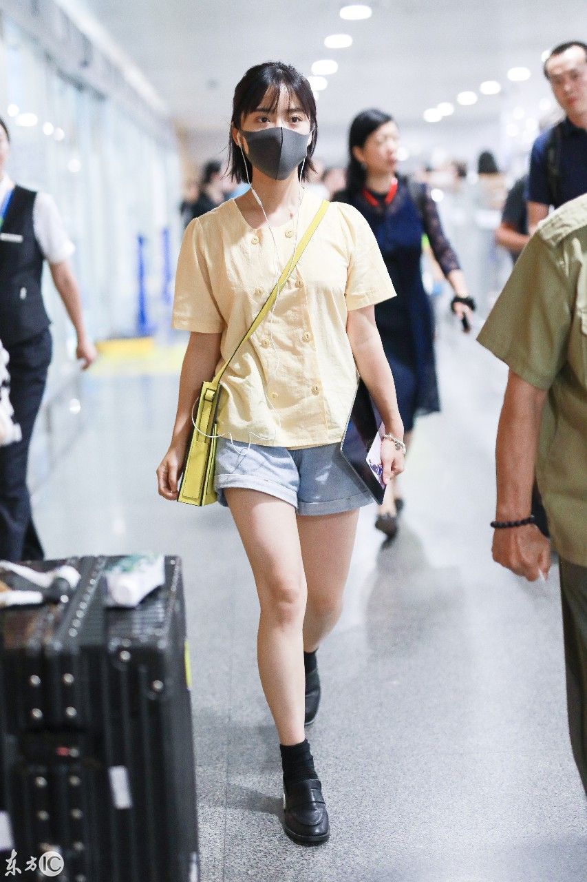 沈月身着T恤短裤，搭配黑色皮鞋亮相机场，步伐轻松自然!