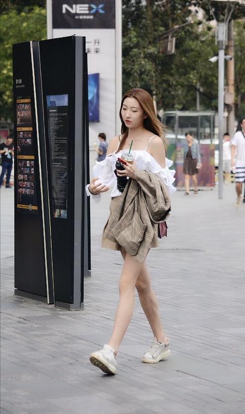 路人街拍，白色的细吊带上衣很好的衬托了小姐姐迷人的锁骨