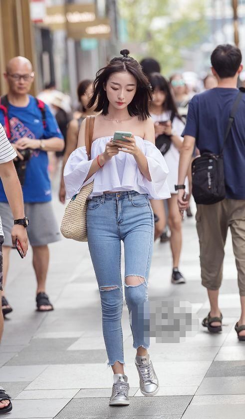 街拍：小姐姐下身的牛仔裤是浅蓝色的紧身款式，简单又大气