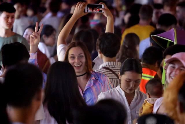 外国游客扎堆逛小吃街,小伙忙着吃串,美女专挑人多的地方留影