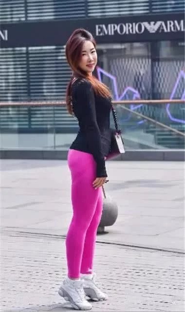 小姐姐身穿粉色运动紧身裤搭配黑色长袖衫显出曲线身材，每走一步