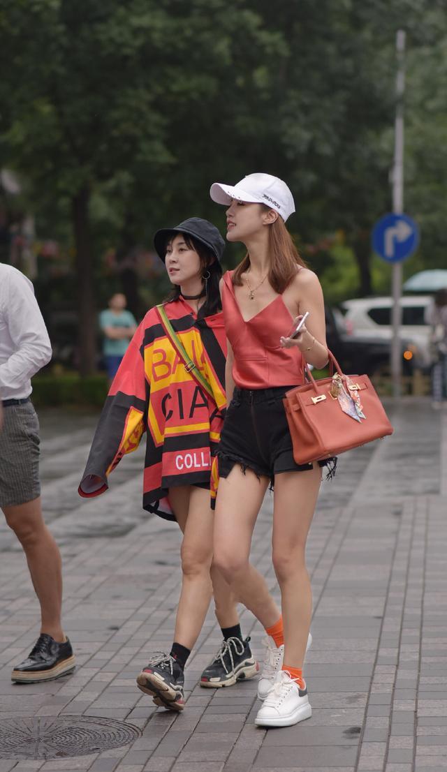 街拍：夏日街头的美女皮肤白皙，一件吊带裙时尚中透露出一丝性感