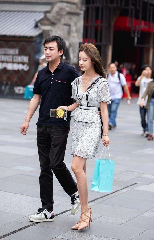 路人街拍，白色的吊带蕾丝裙很好的展现出了小姐姐的白皙肌肤