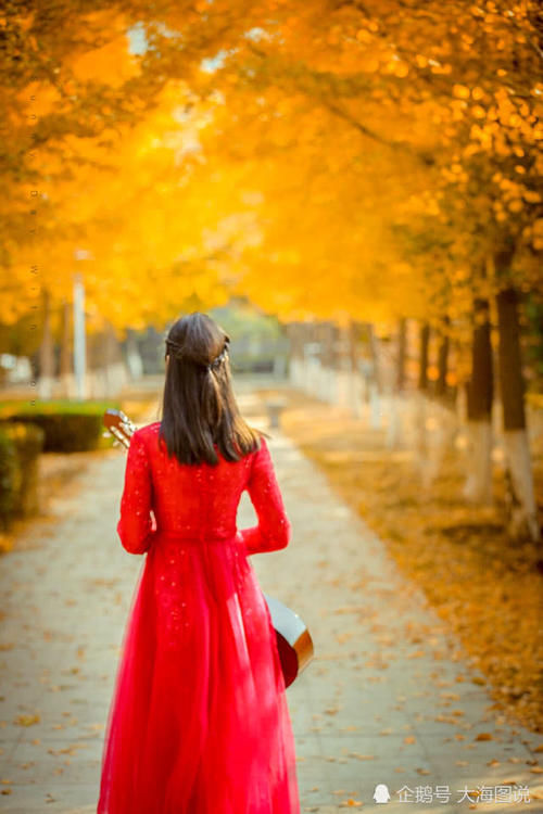 身着红裙怀抱吉他，徜徉在美丽的秋天里！