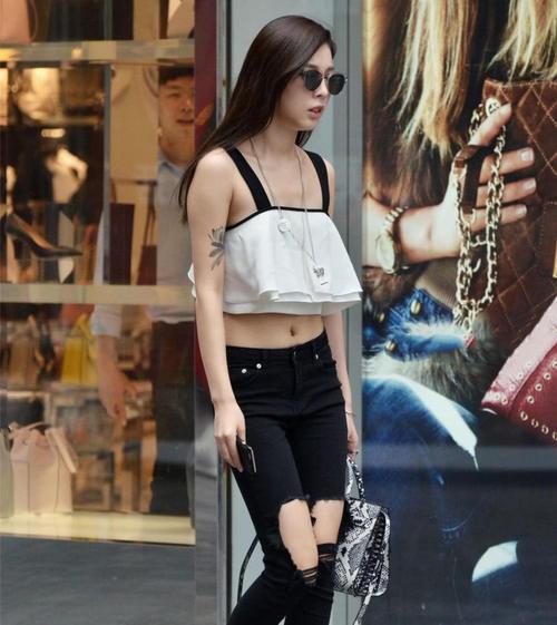 路人街拍：小姐姐白色吊带背心搭配紧身牛仔裤，成熟又有气质！