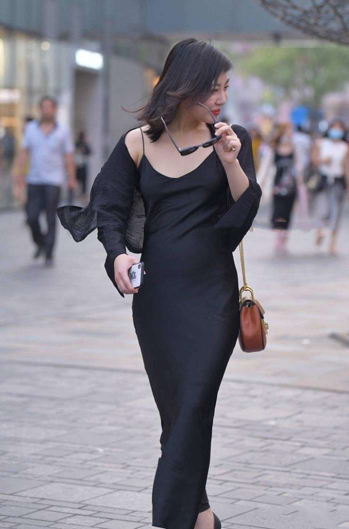 美女深色打扮, 透露出婀娜多姿的身段, 举手投足尽显魅力