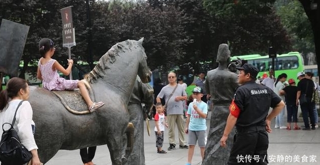 游客攀爬景区雕塑拍照，保安喊话劝告无效，沉默地递上一牌子