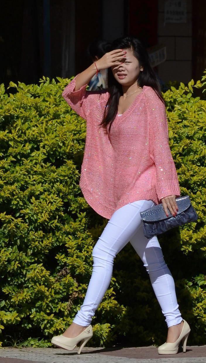 公园里街拍:白色紧身裤美女展现出线条的优美，清新脱俗很吸引人