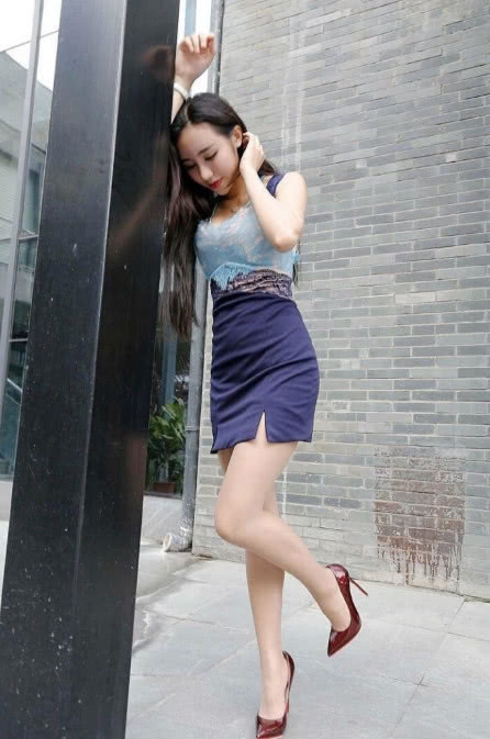 小姐姐吊带连身短裙尽显凹凸有致的身材,街头摆拍风格多变