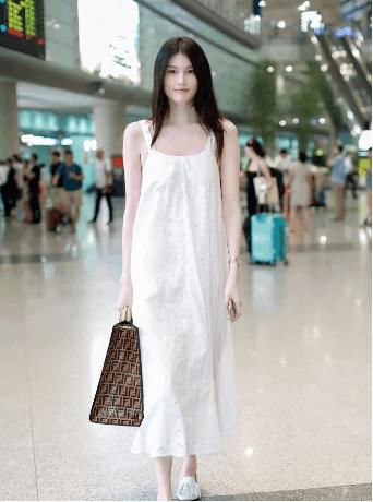 何穗一身白裙亮相机场，长发飘飘，气质动人，校园女神无疑了