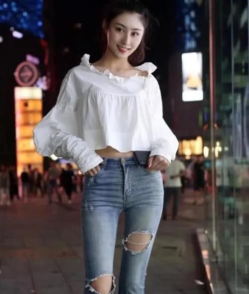  #出自己的时#潮范儿女神来了，街拍：面带微笑的小姐姐，一件白色上衣配漏洞牛仔裤，青春靓丽范