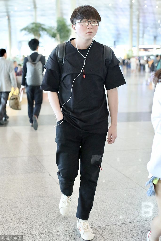 毛不易全黑look扮酷机场边走边听歌 “苹果脸”配“西瓜头”自带