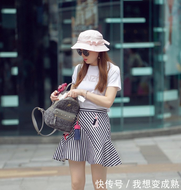 路人街拍，皮肤白皙的美女穿露脐装配紧身牛仔裤，身材妩媚而性感