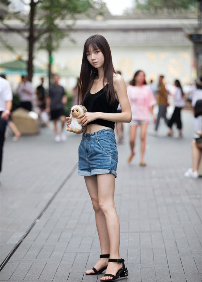 路人街拍：黑背心和牛仔短裤的穿搭，秀出小姐姐高挑迷人的身材