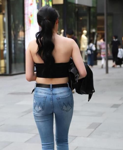  「休闲裤」街拍：身材高挑的美女，一件米黄色上衣配橘红色休闲裤，气质十足