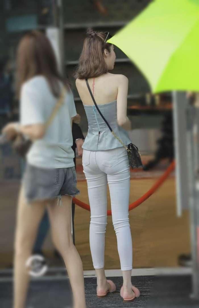 美女淡蓝色露肩的抹胸上衣真是好看，只是现身紧身牛仔裤有点尴尬