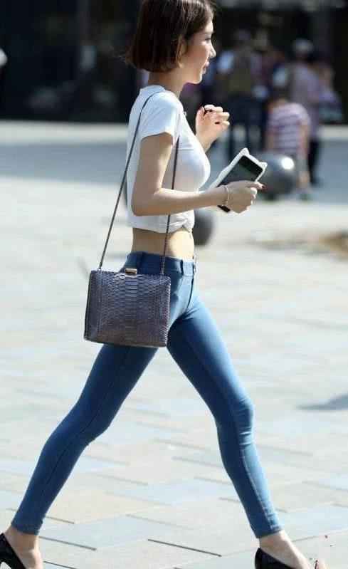 蘑菇头小姐姐浅蓝色潮修身牛仔裤裹出丰满的臀线，羞涩感让人吸睛