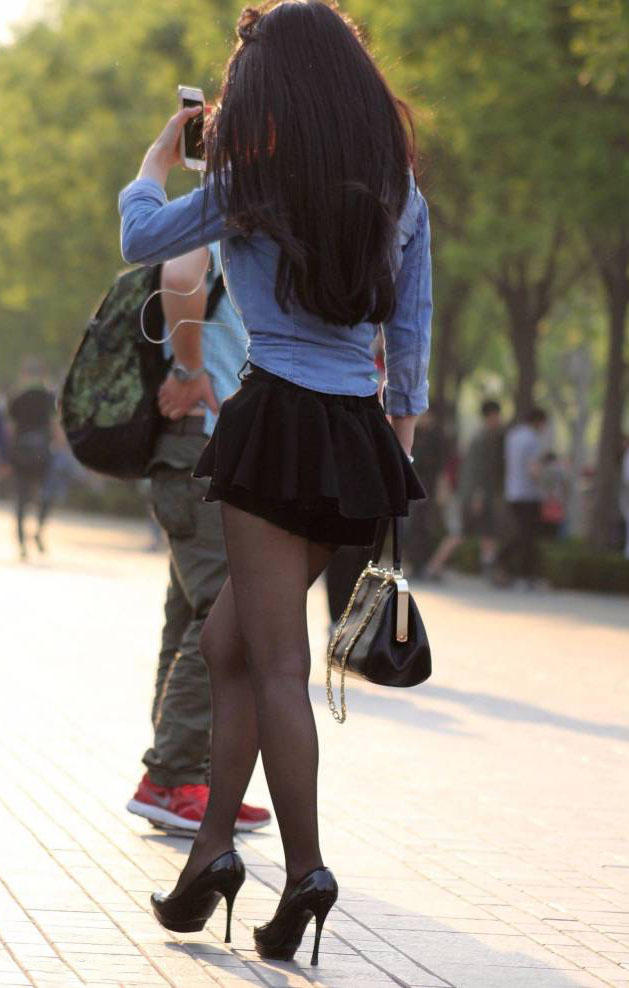 成熟少妇穿超短裙配黑丝袜高跟鞋，秀出一双纤细修长的美腿很有女