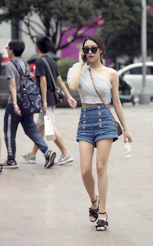 路人街拍：小姐姐白色吊带背心搭配紧身牛仔裤，成熟又有气质！