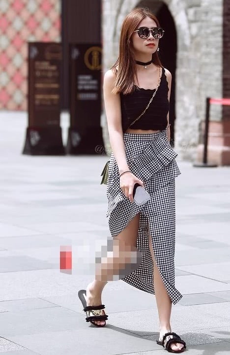 小姐姐黑白格子的长裙搭配紧身上衣，显得女人味十足