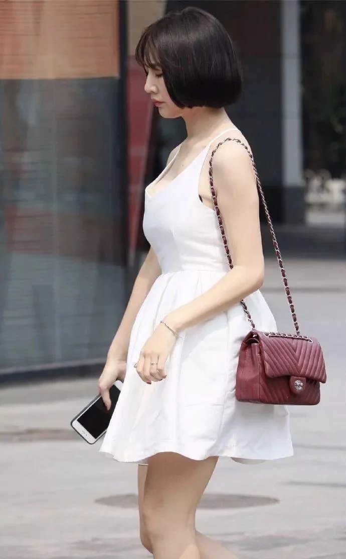 拿手机的小姐姐身穿雪白连衣裙，销魂的背景迷倒一群人