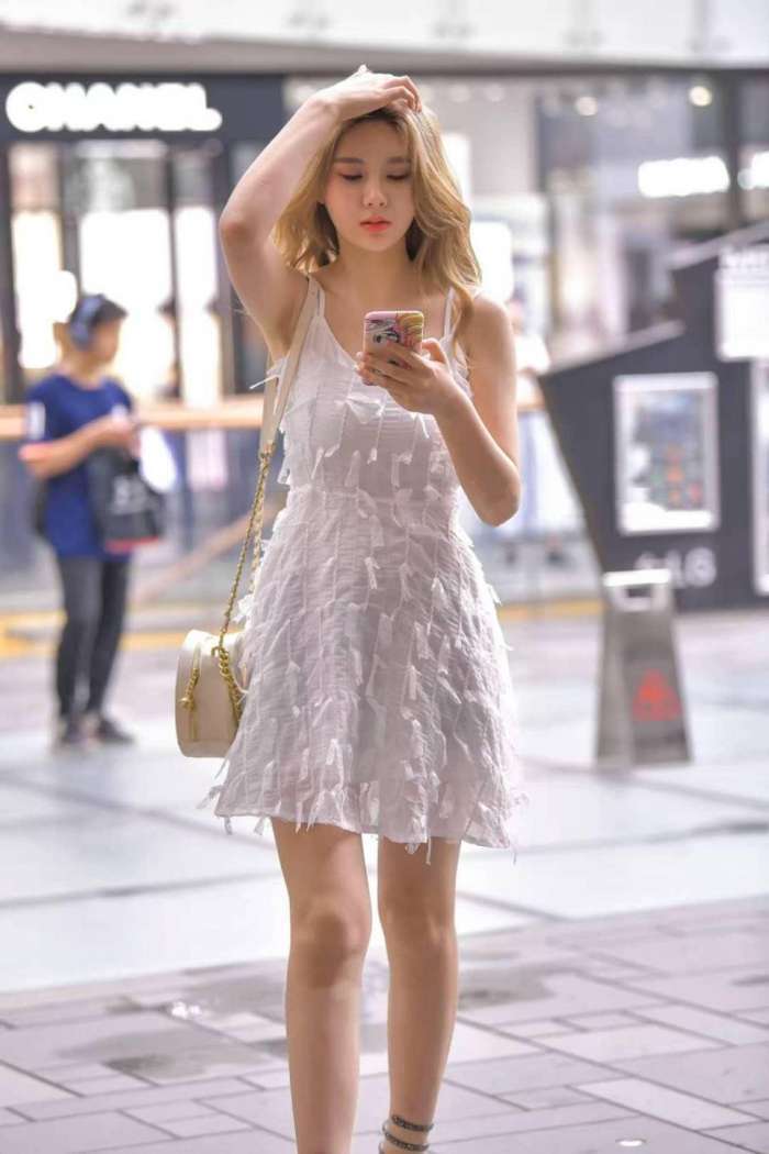 图中小姐姐身穿白色吊带连衣裙, 干净又清爽