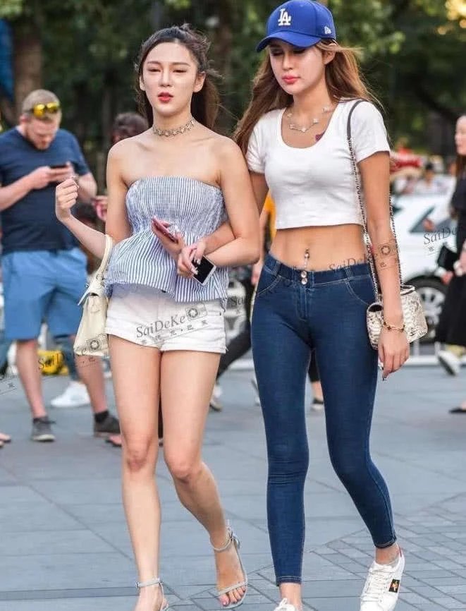 紧身裤小姐姐双腿修长，旁边的闺蜜则是一个超短裤，腼腆的笑容很