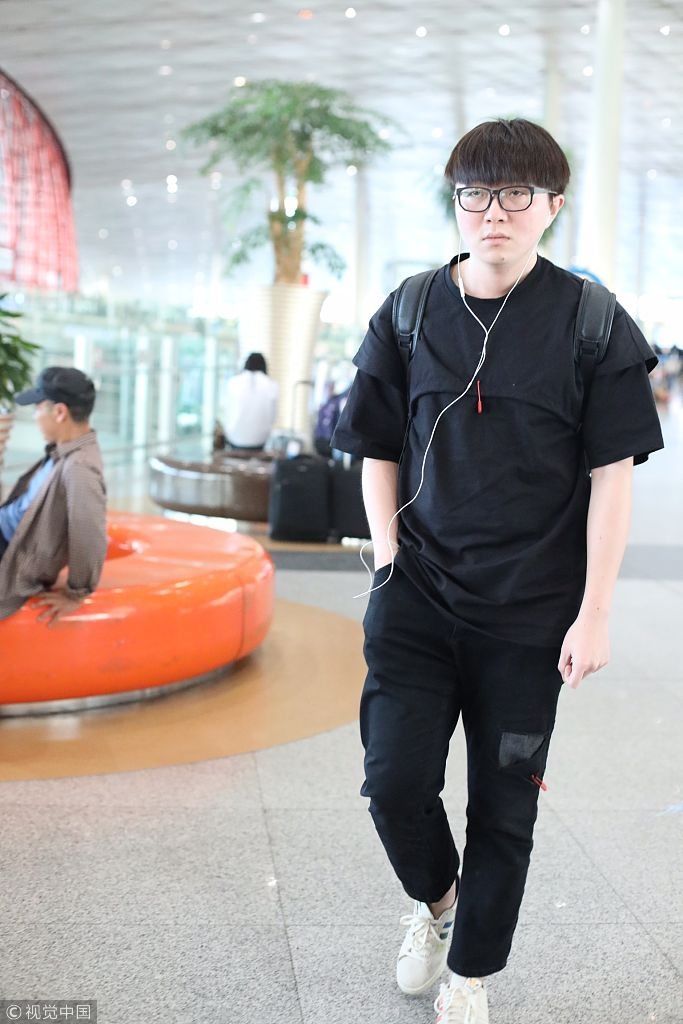 毛不易全黑look扮酷机场边走边听歌 “苹果脸”配“西瓜头”自带