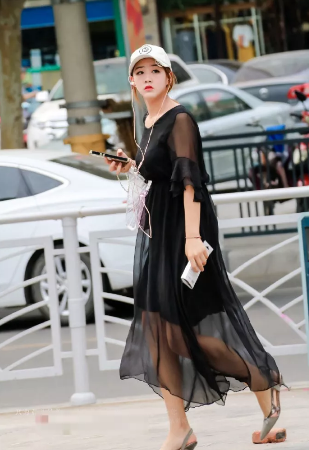 街拍头戴遮阳帽身穿黑色薄纱连衣裙的美女小姐姐