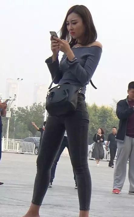 紧身露肩上衣搭配贴身牛仔裤，简约时尚