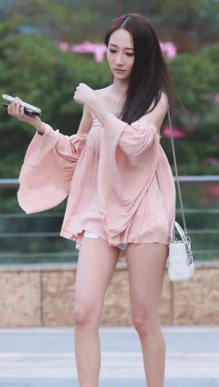  [粉色]街拍身穿粉色一字肩上衣的小美女，肌肤如玉，尊贵优雅显大气